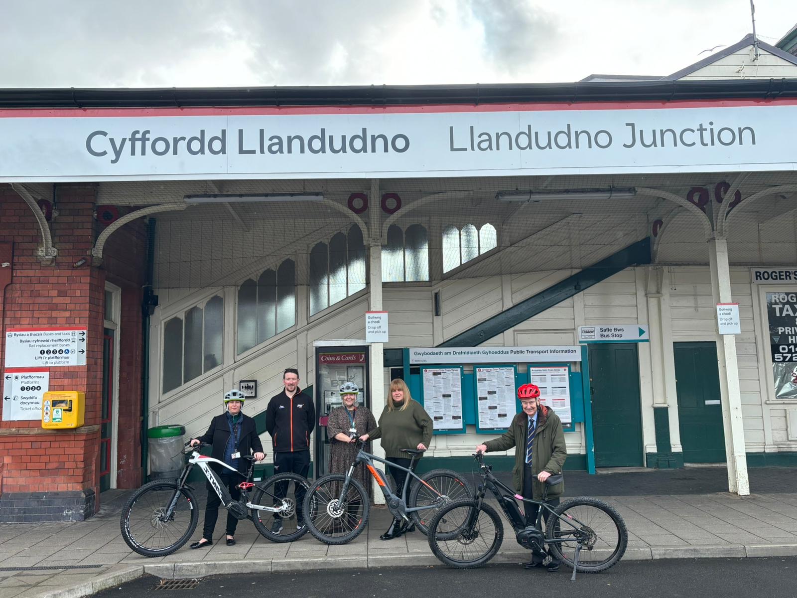 Group of cyclists standing in front of Llandudno Junction railway station.
